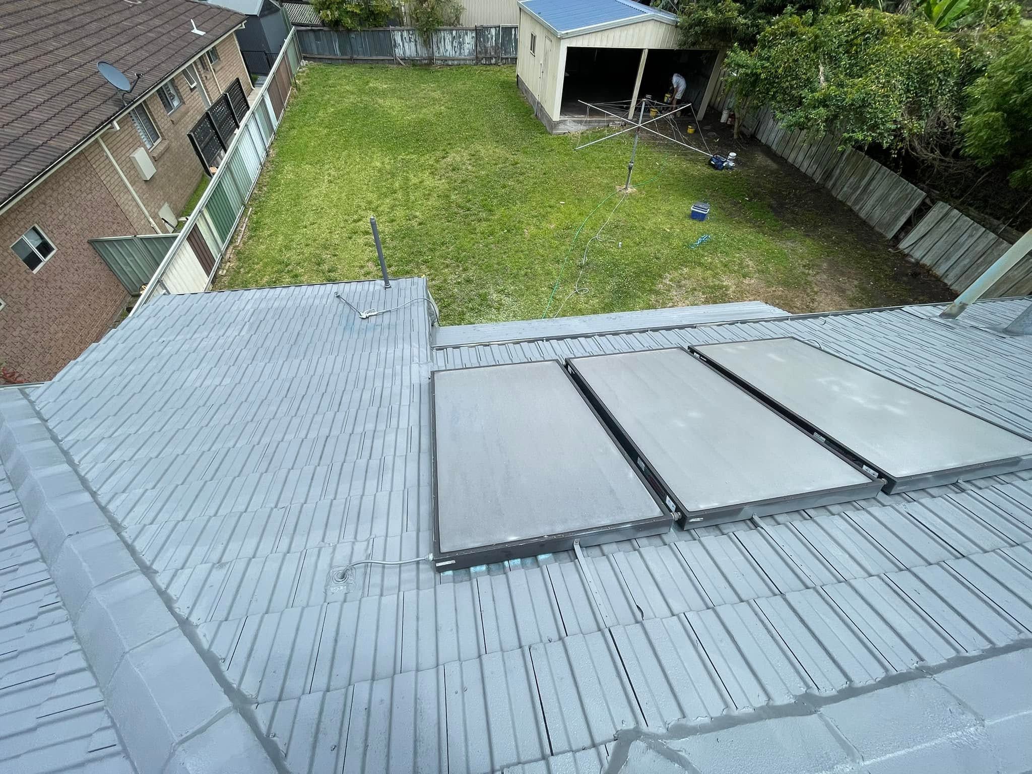 Grey tile roof with solar panels after a roof restoration