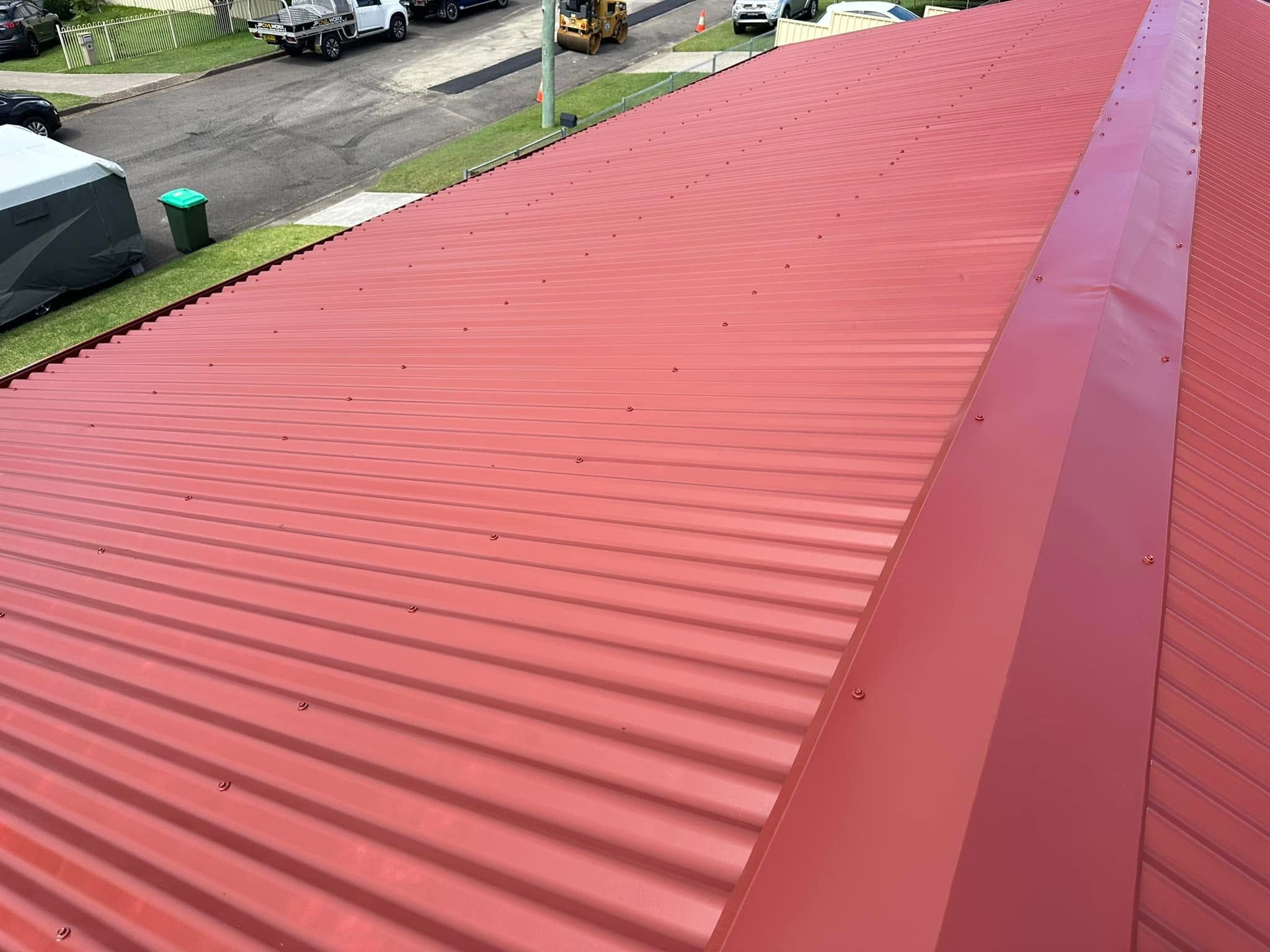 Red metal roof ridge after a roof coating