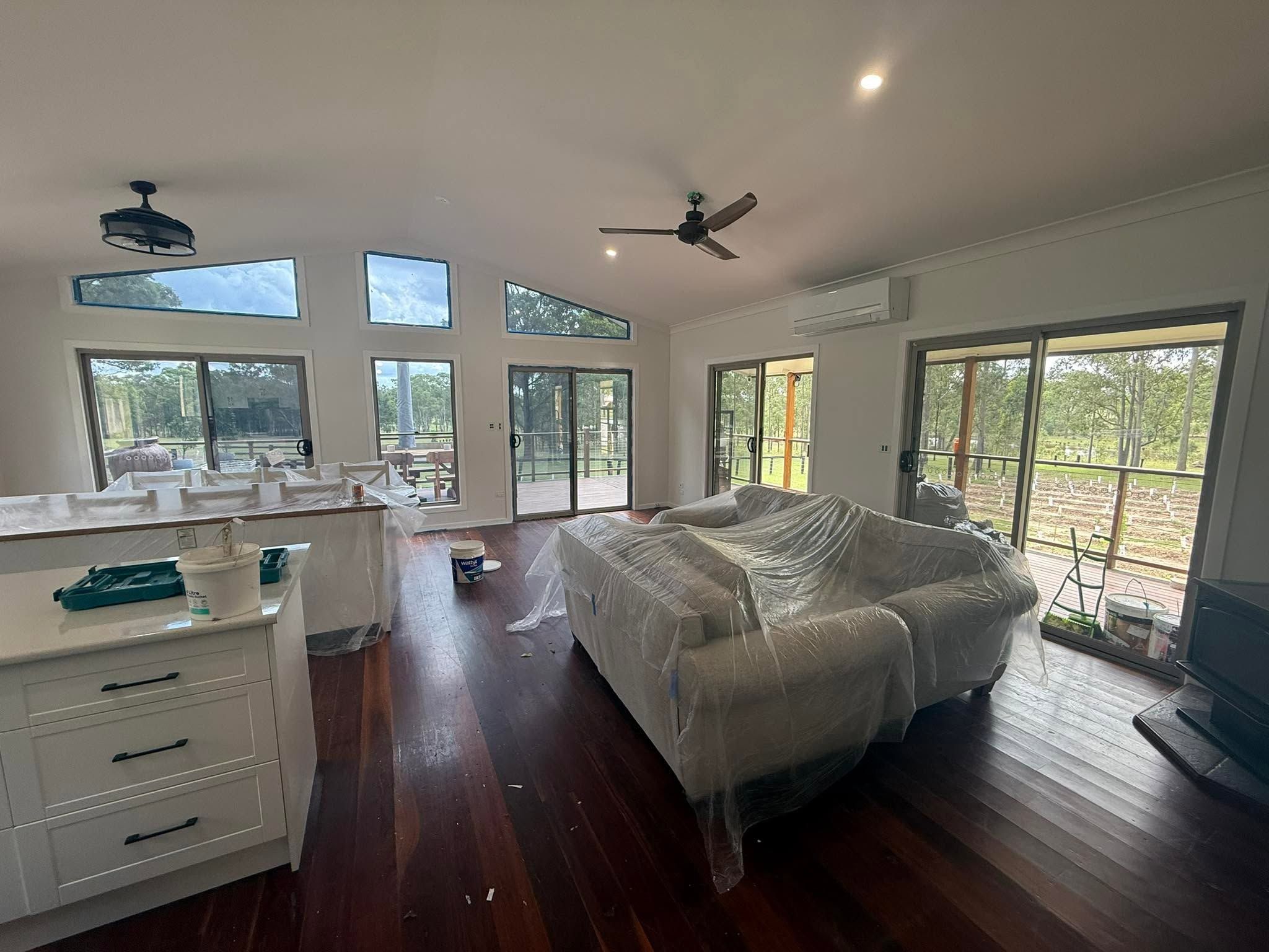 Open living area with drop sheets down during interior painting