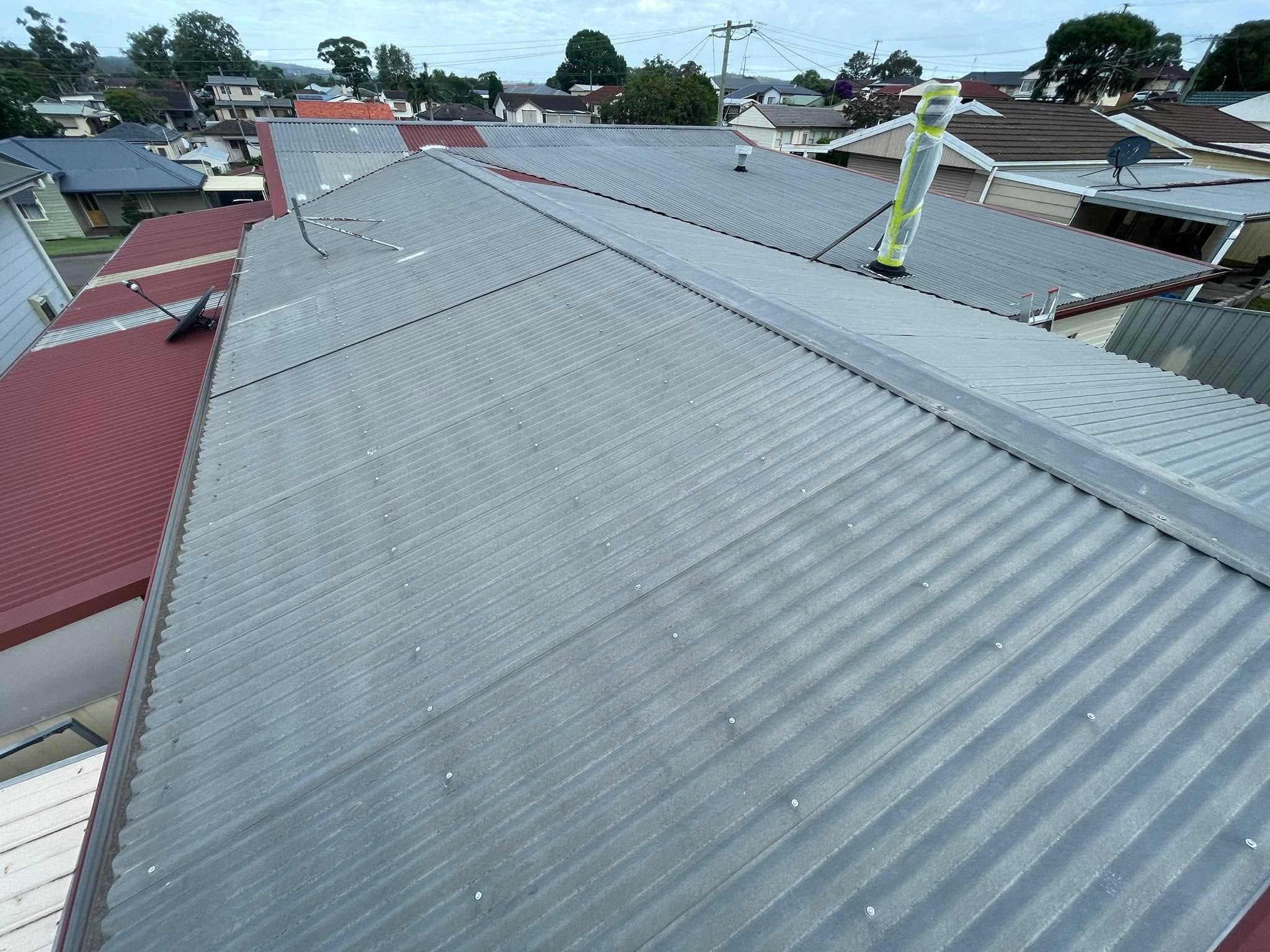 Repainted grey metal roof above a street of homes