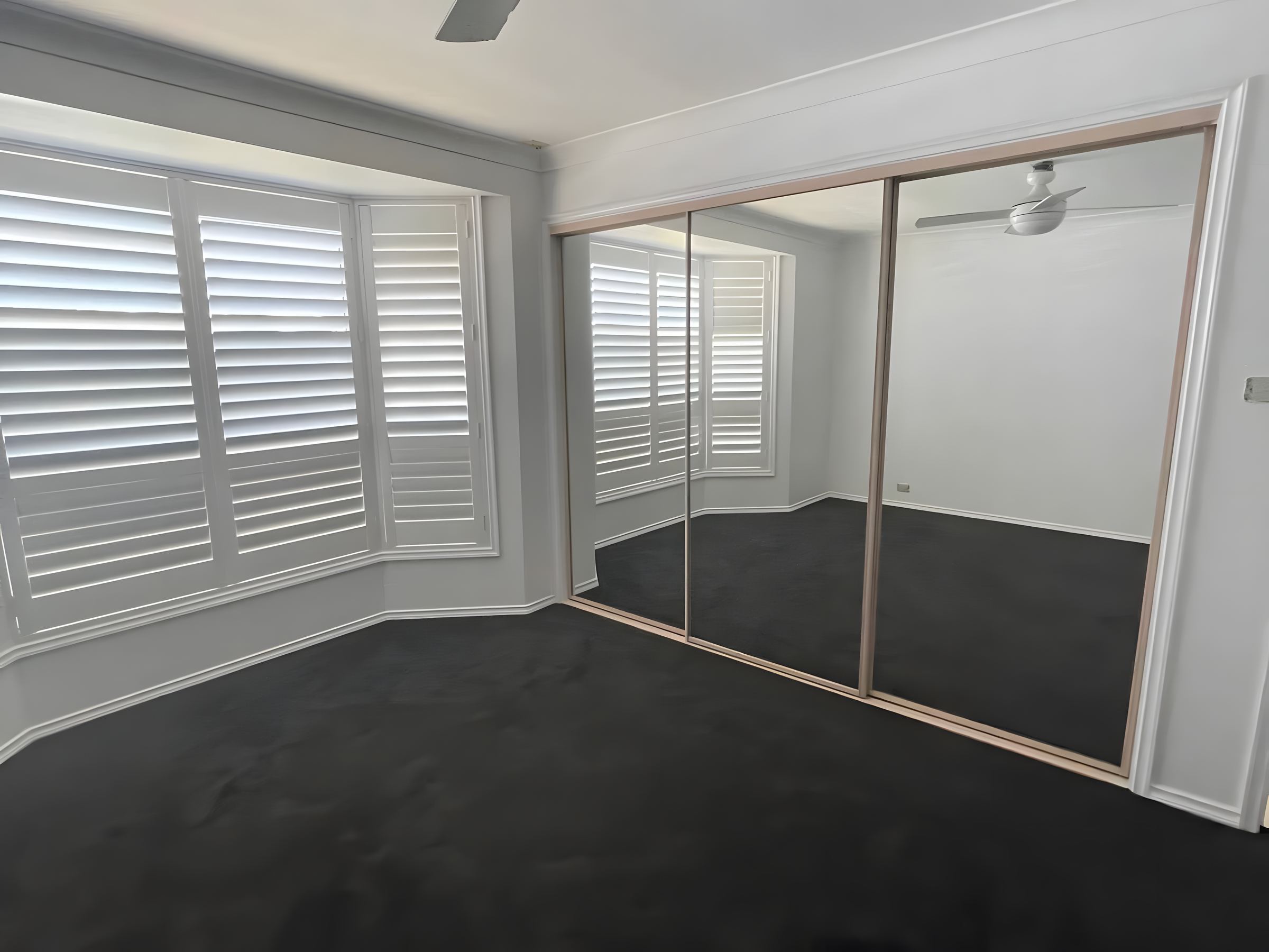 Bedroom with plantation shutters after painting