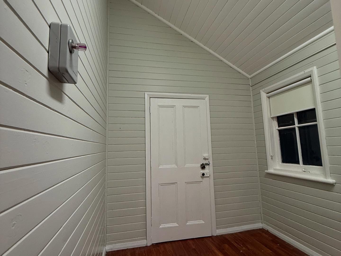 Freshly painted room with VJ panelled walls and a window