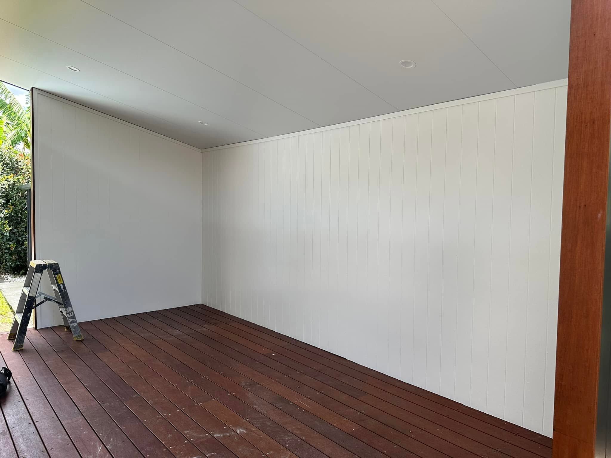 Outdoor room with a white painted wall on a deck