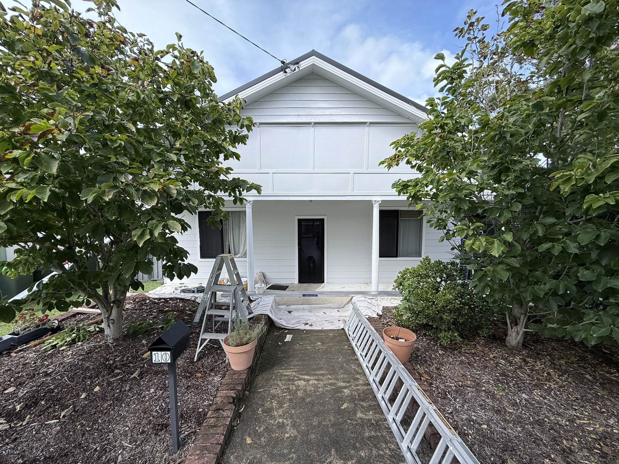White weatherboard home and timber verandah from the Hughesys Painting job gallery