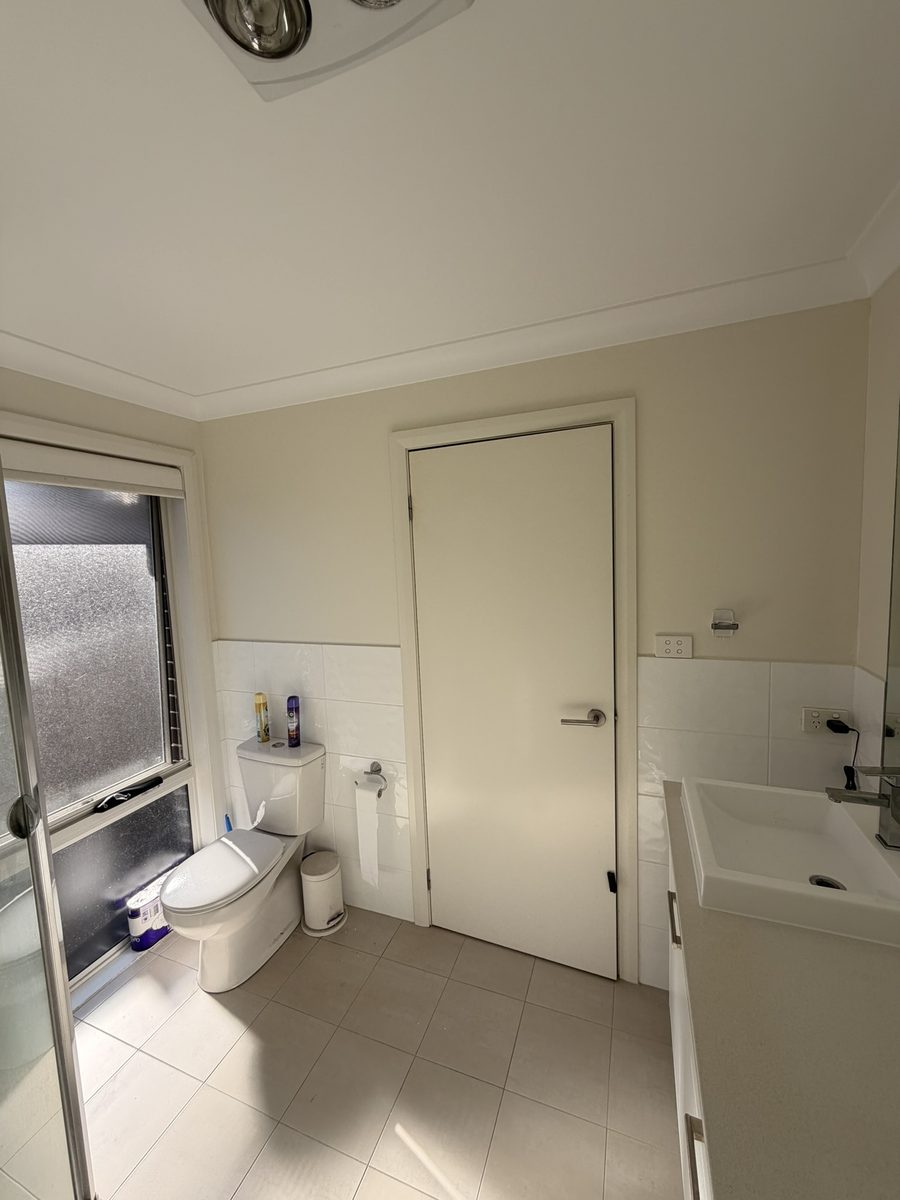 Cameron Park bathroom with a window over the toilet, a vanity and freshly painted cream walls